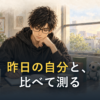 窓辺の机で、眼鏡の男性が手を口元に当てて、ノートに書き込んでいる。机の上には小さなロボットと積まれた本。「昨日の自分と、比べて測る」の文字入り